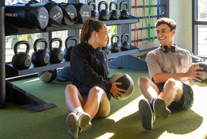 two friends work out in a fitness center